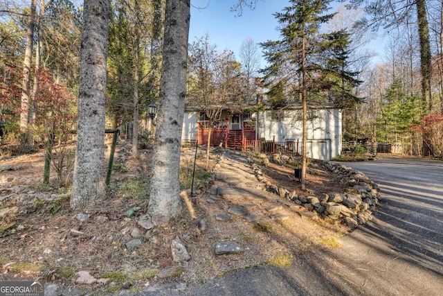 view of property hidden behind natural elements featuring a garage