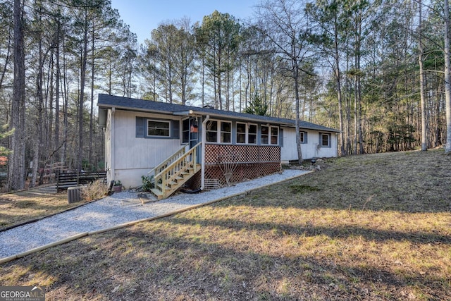 single story home featuring a sunroom and a front yard