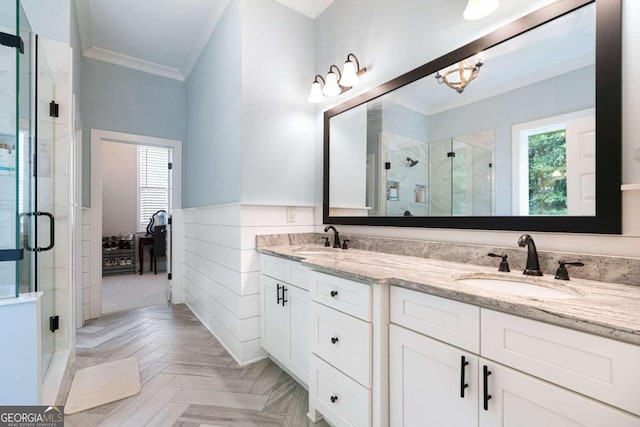 bathroom featuring parquet flooring, a shower with door, vanity, and ornamental molding