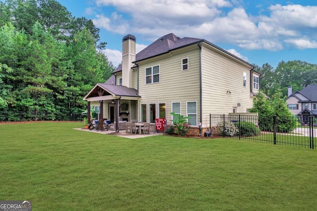 rear view of house with a patio area and a yard