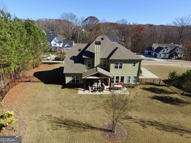 back of property featuring a patio area and a yard