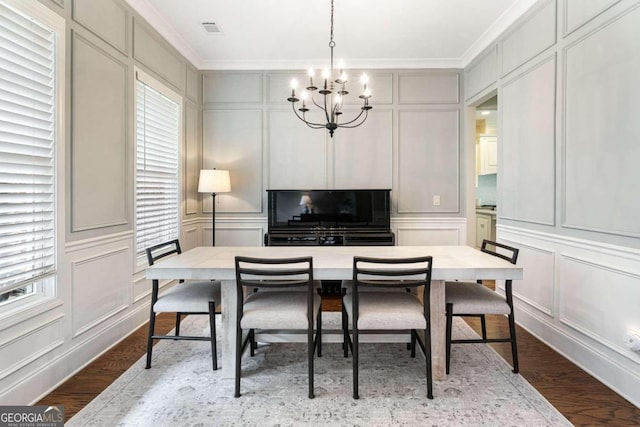 dining area featuring light hardwood / wood-style floors, an inviting chandelier, and ornamental molding