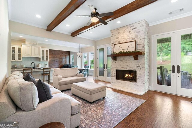 living room with beamed ceiling, plenty of natural light, and french doors