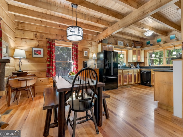 dining area featuring wooden ceiling, a healthy amount of sunlight, and wood walls