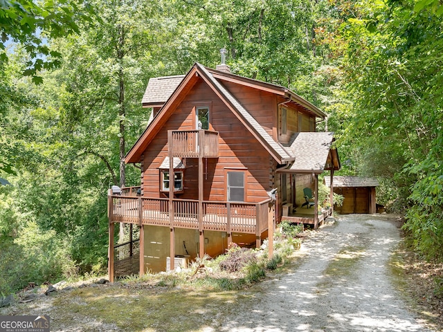 log-style house with an outdoor structure and a deck