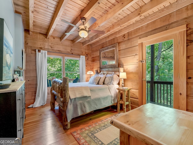 bedroom featuring beam ceiling, wooden walls, ceiling fan, and wood-type flooring