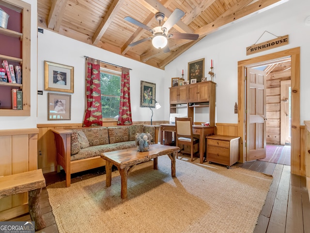 living room with wooden walls, hardwood / wood-style flooring, vaulted ceiling with beams, ceiling fan, and wood ceiling