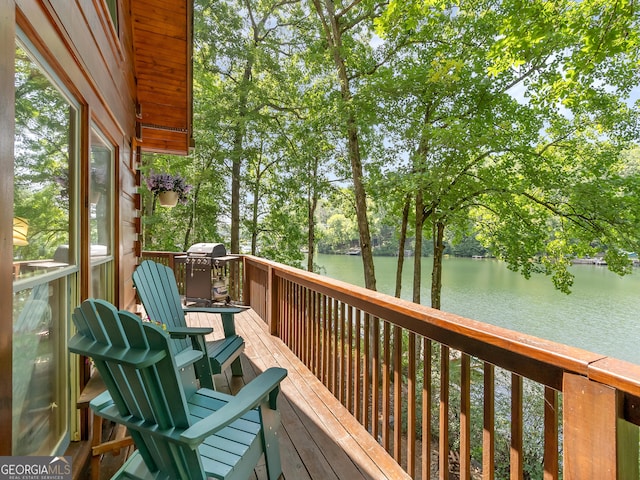 wooden deck featuring grilling area and a water view