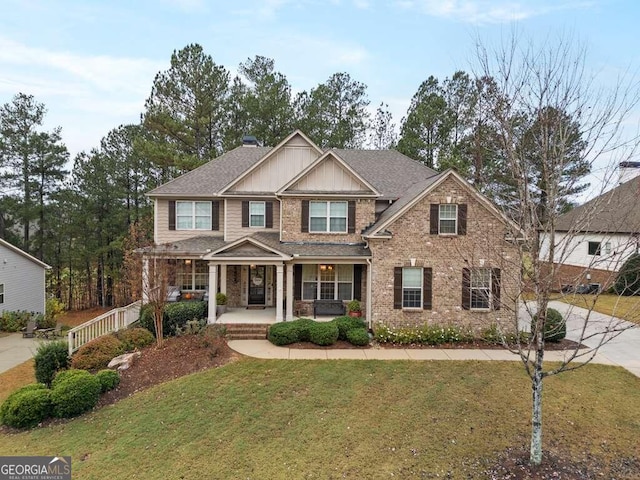 craftsman house with a porch and a front lawn