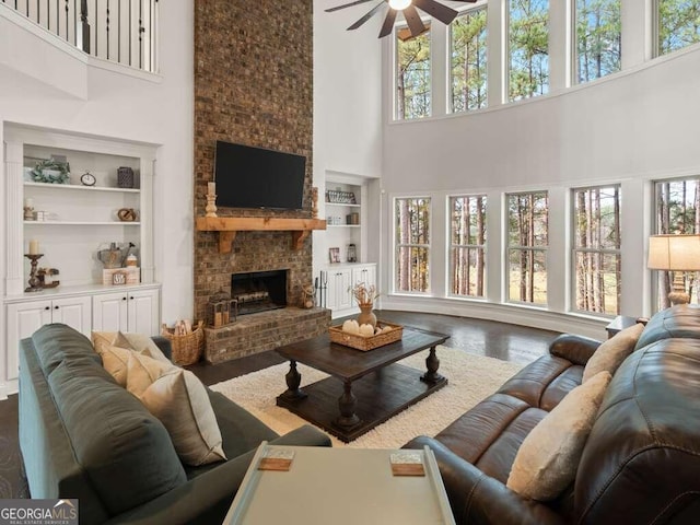 living room featuring built in features, a wealth of natural light, and a towering ceiling