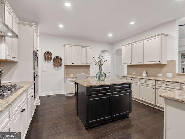 kitchen with stainless steel appliances, decorative backsplash, white cabinets, and dark wood-type flooring