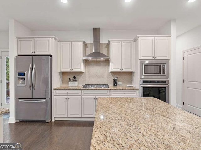 kitchen featuring white cabinets, stainless steel appliances, dark hardwood / wood-style floors, and wall chimney exhaust hood