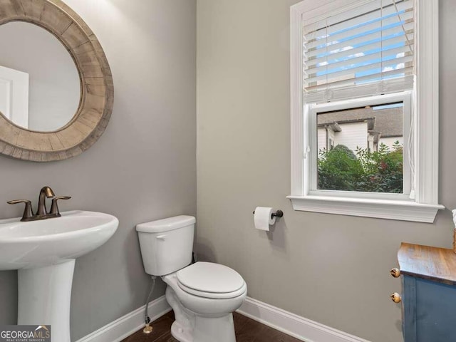 bathroom with a healthy amount of sunlight, toilet, and sink