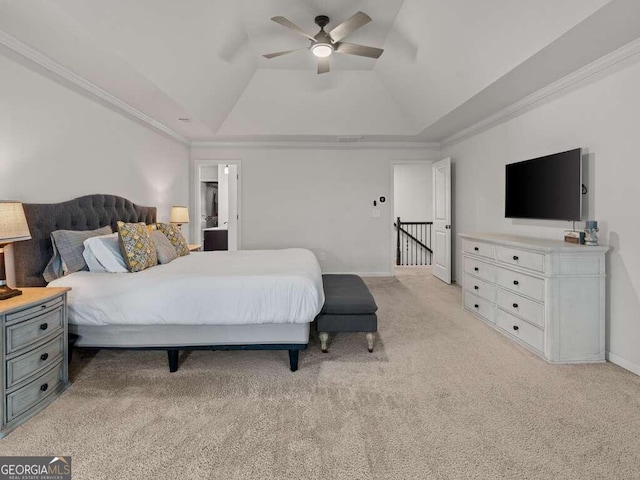 carpeted bedroom with vaulted ceiling, a raised ceiling, ceiling fan, and ornamental molding