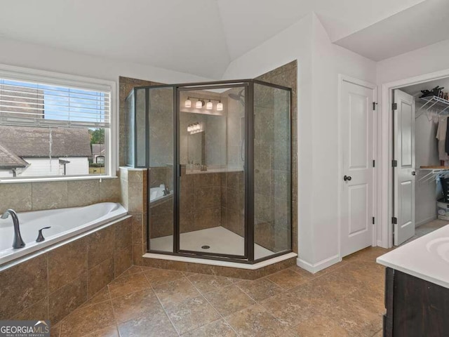 bathroom featuring plus walk in shower, vanity, and vaulted ceiling