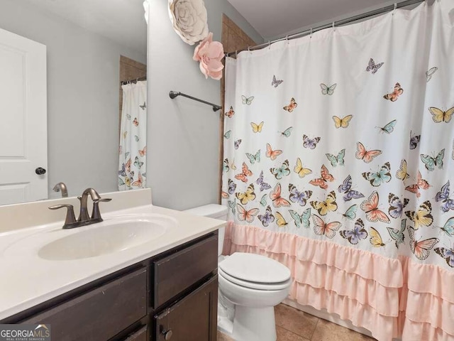 bathroom featuring tile patterned flooring, vanity, curtained shower, and toilet