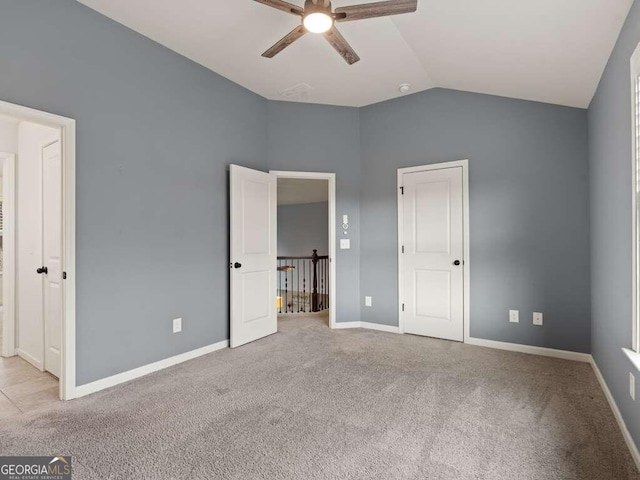 unfurnished bedroom featuring ceiling fan, light colored carpet, and vaulted ceiling