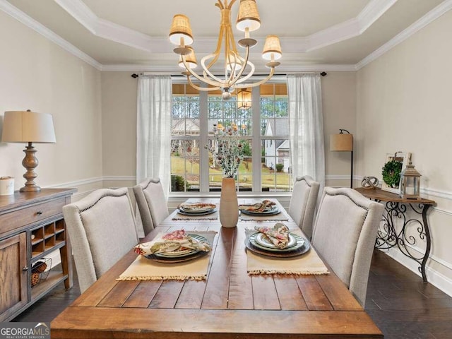 dining room with a tray ceiling, crown molding, dark hardwood / wood-style floors, and a notable chandelier