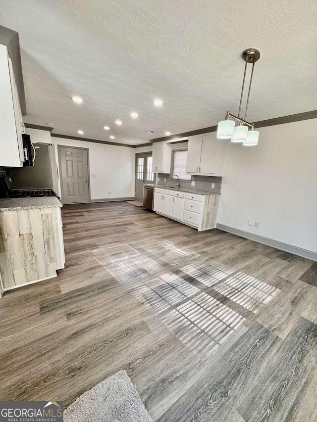 kitchen featuring dishwasher, hanging light fixtures, a textured ceiling, white cabinets, and light wood-type flooring