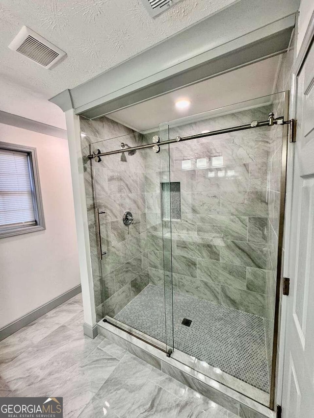 bathroom featuring a textured ceiling and walk in shower