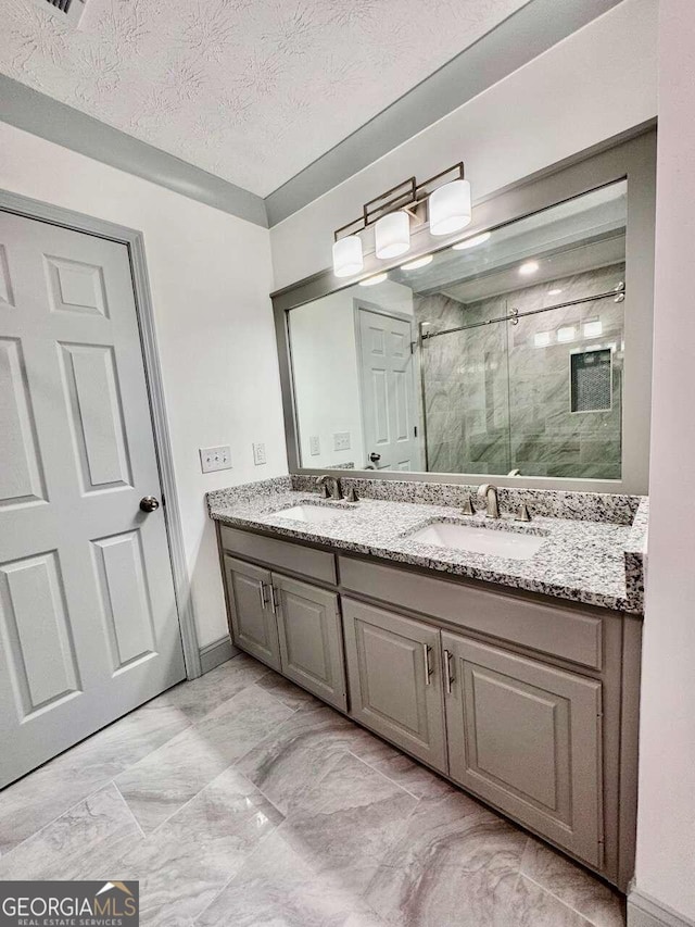 bathroom featuring vanity, a textured ceiling, and an enclosed shower