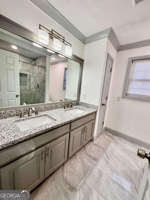 bathroom featuring a textured ceiling, vanity, and an enclosed shower