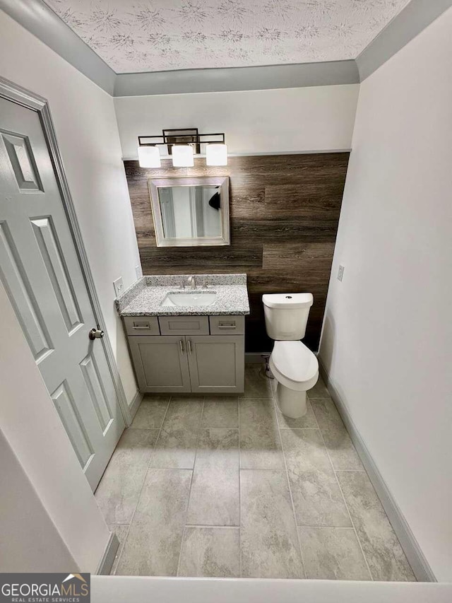 bathroom featuring vanity, toilet, and a textured ceiling