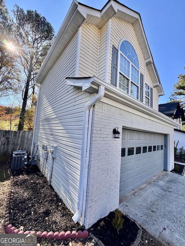 view of home's exterior with a garage and central AC unit