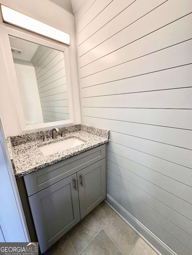 bathroom with vanity and wood walls