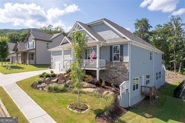 craftsman house featuring covered porch, a garage, and a front yard