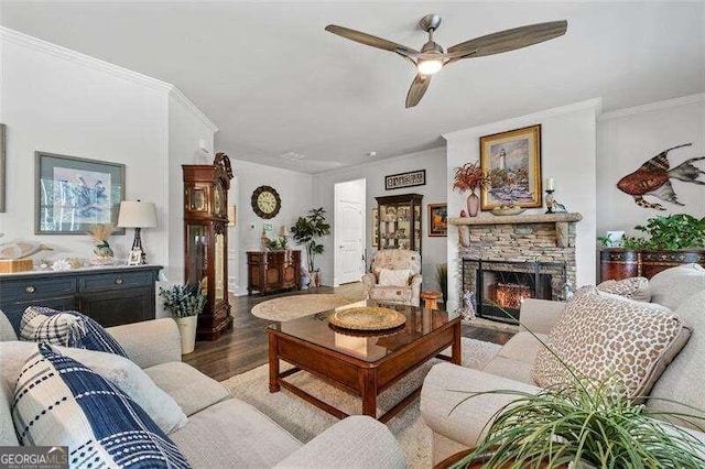 living room with hardwood / wood-style flooring, ceiling fan, ornamental molding, and a fireplace