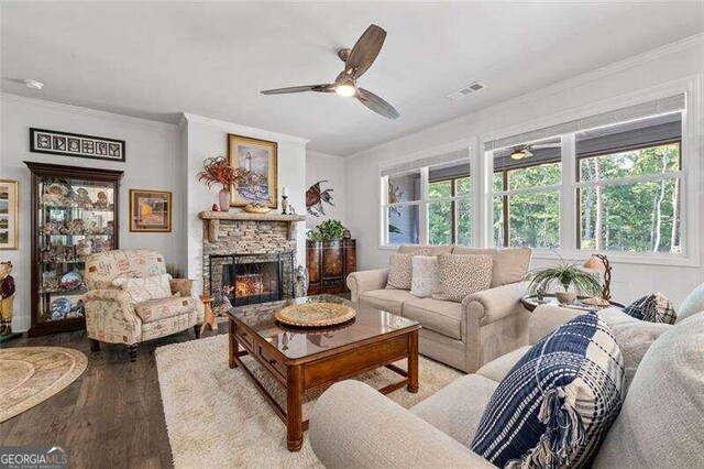 living room with crown molding, a fireplace, ceiling fan, and hardwood / wood-style flooring