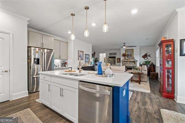 kitchen featuring sink, hanging light fixtures, dark hardwood / wood-style floors, an island with sink, and appliances with stainless steel finishes