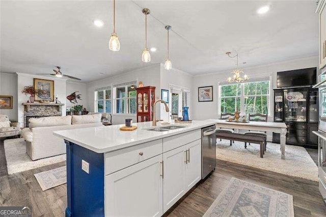 kitchen featuring sink, a kitchen island with sink, white cabinets, ceiling fan with notable chandelier, and appliances with stainless steel finishes