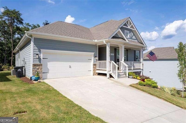 view of front of property with a front yard, a garage, and covered porch