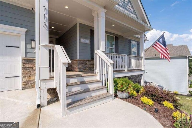 entrance to property featuring a porch and a garage