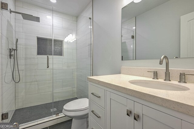 bathroom with vanity, toilet, and a shower with shower door