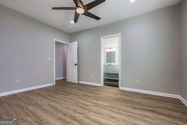 unfurnished bedroom featuring ensuite bath, ceiling fan, and light hardwood / wood-style floors