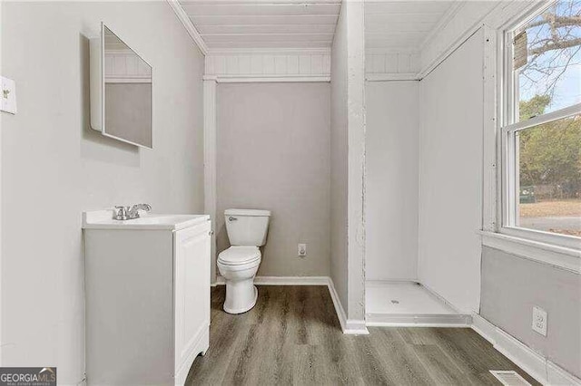 bathroom with vanity, a shower, hardwood / wood-style flooring, toilet, and ornamental molding