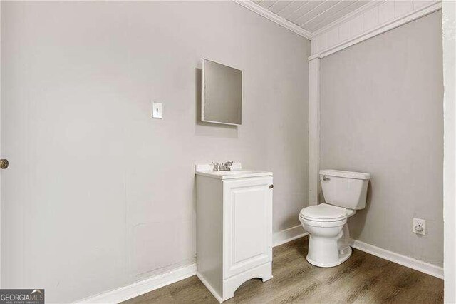 bathroom featuring hardwood / wood-style floors, vanity, toilet, and ornamental molding