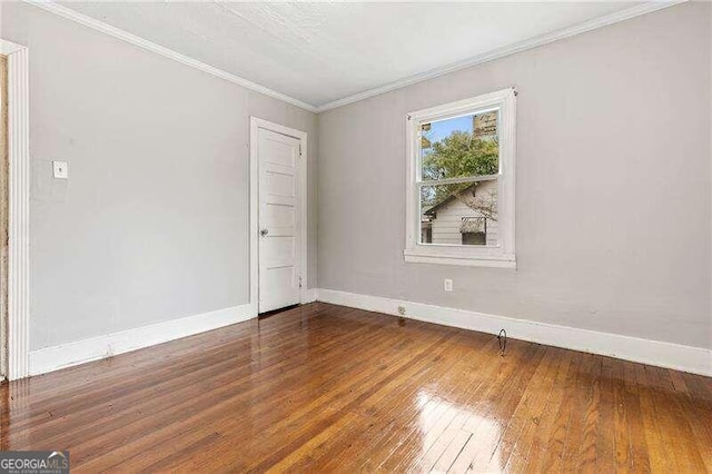 spare room with crown molding and dark hardwood / wood-style flooring