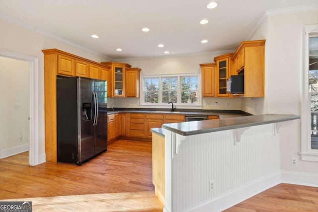 kitchen featuring kitchen peninsula, appliances with stainless steel finishes, and light hardwood / wood-style flooring