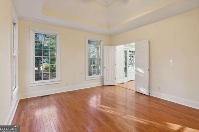 unfurnished room featuring hardwood / wood-style floors and a tray ceiling