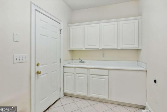 washroom with sink, light tile patterned floors, cabinets, and hookup for an electric dryer