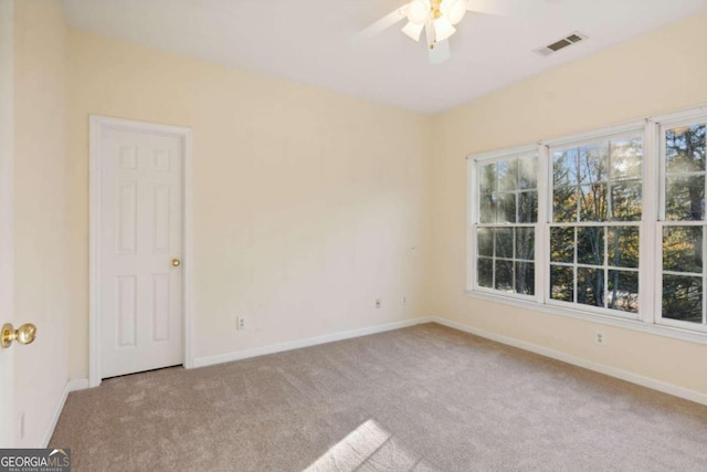 carpeted spare room featuring ceiling fan