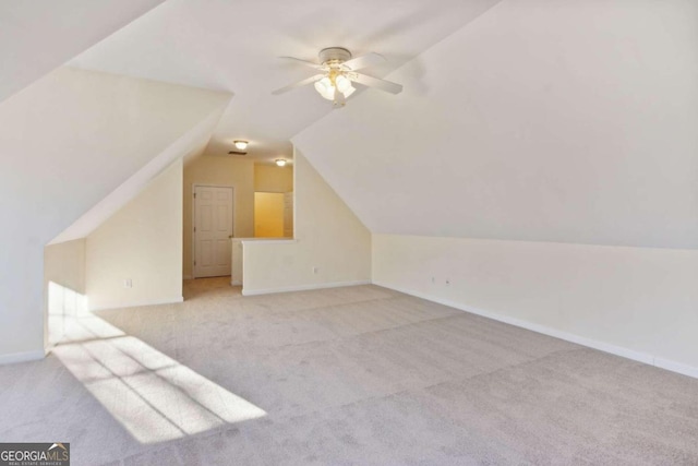 additional living space with light carpet, vaulted ceiling, and ceiling fan