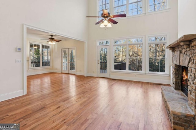 unfurnished living room with a fireplace, light hardwood / wood-style flooring, and plenty of natural light