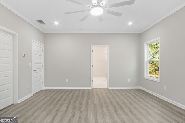 unfurnished bedroom with light hardwood / wood-style floors, a spacious closet, ceiling fan, and crown molding