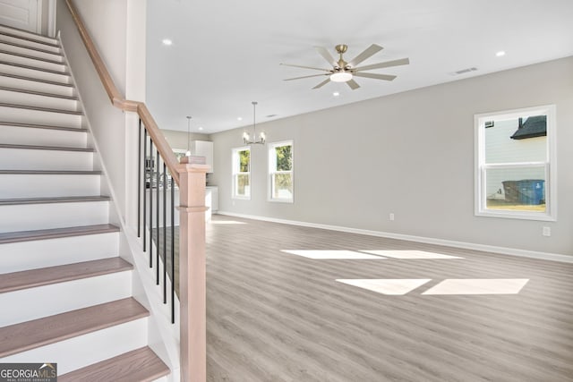 interior space with hardwood / wood-style floors and ceiling fan with notable chandelier