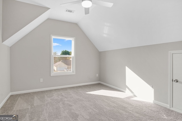 additional living space with light colored carpet, ceiling fan, and lofted ceiling